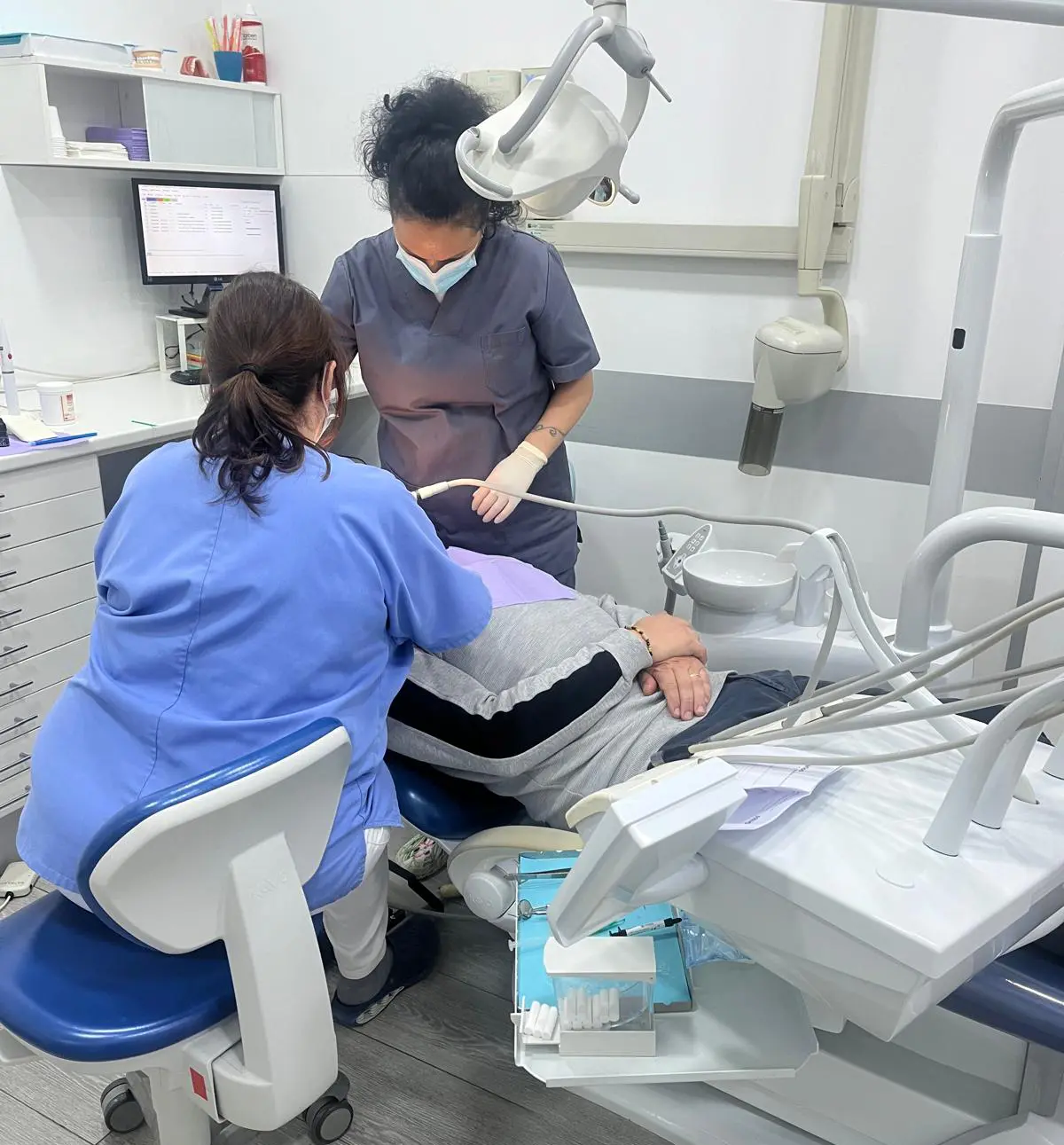Dos profesionales de la Clínica Dental Vilà realizando una limpieza dental, con un enfoque en la salud bucal y el cuidado del paciente