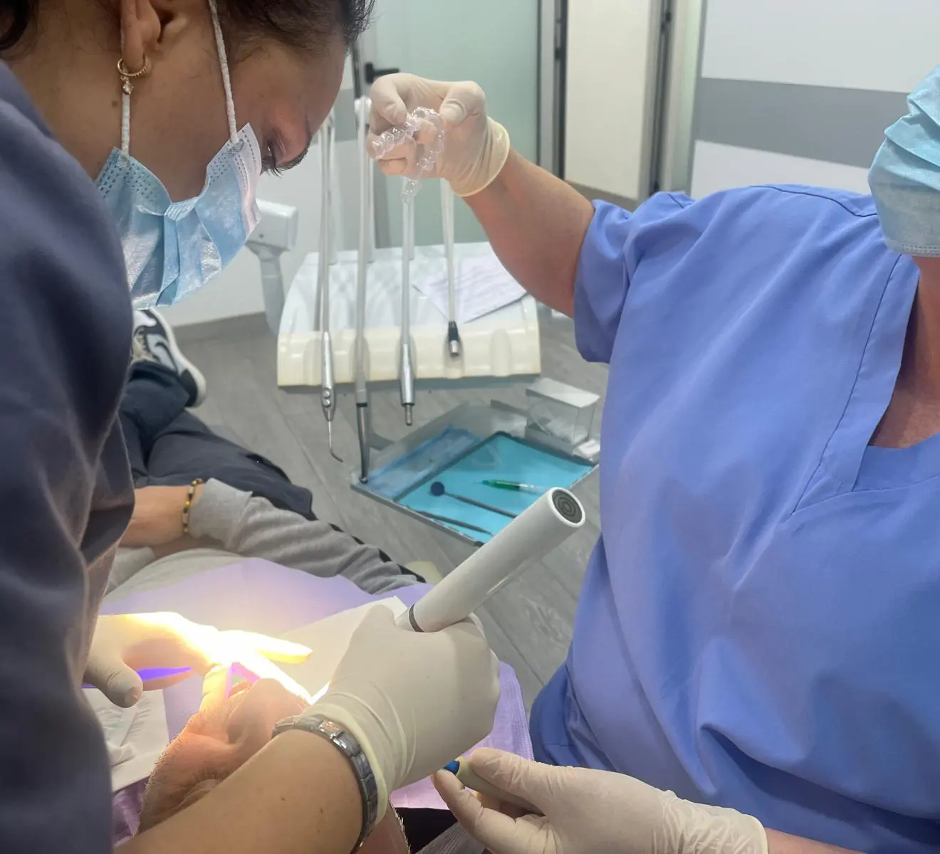 Profesionales de la Clínica Dental Vilà atendiendo a un paciente mientras le colocan su ortodoncia invisible, mostrando el enfoque personalizado en el tratamiento