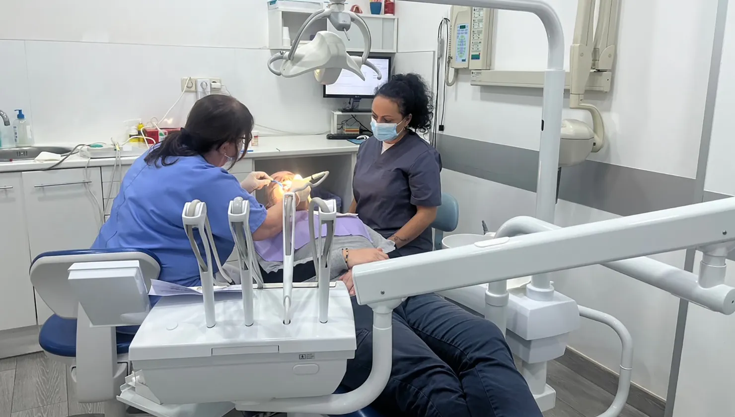 Dos professionals de Clínica Dental Vilà treballant conjuntament amb un pacient, oferint un servei dental de qualitat i professionalisme.