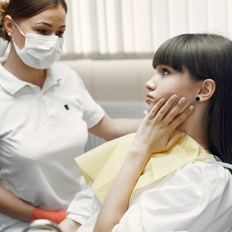 Dentista revisant el somriure d’una pacient en una clínica dental