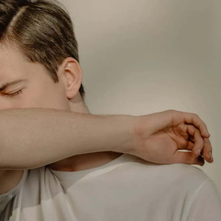 Chico con alergia protegiéndose la boca