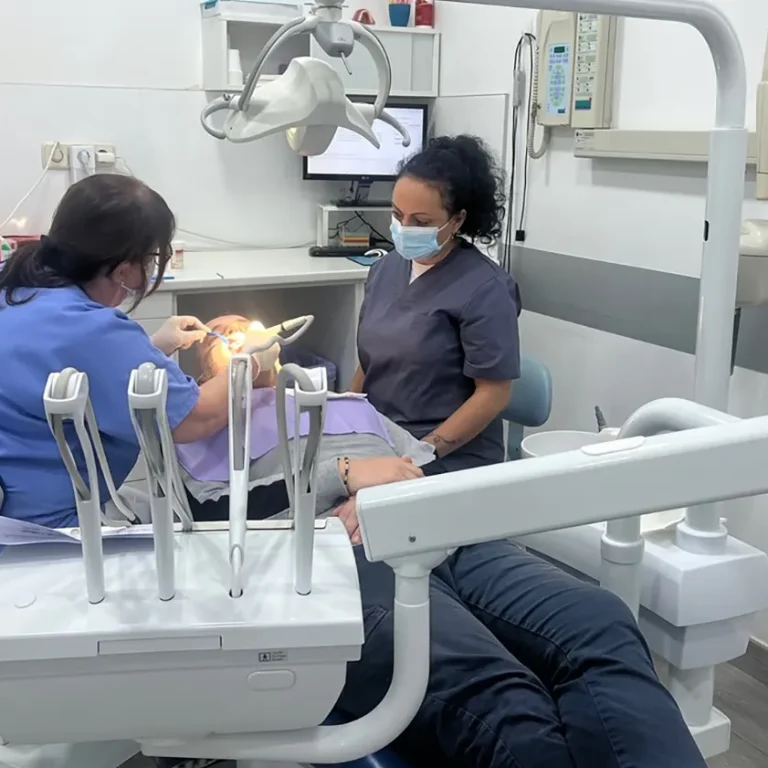 Dos professionals de Clínica Dental Vilà treballant conjuntament amb un pacient, oferint un servei dental de qualitat i professionalisme.