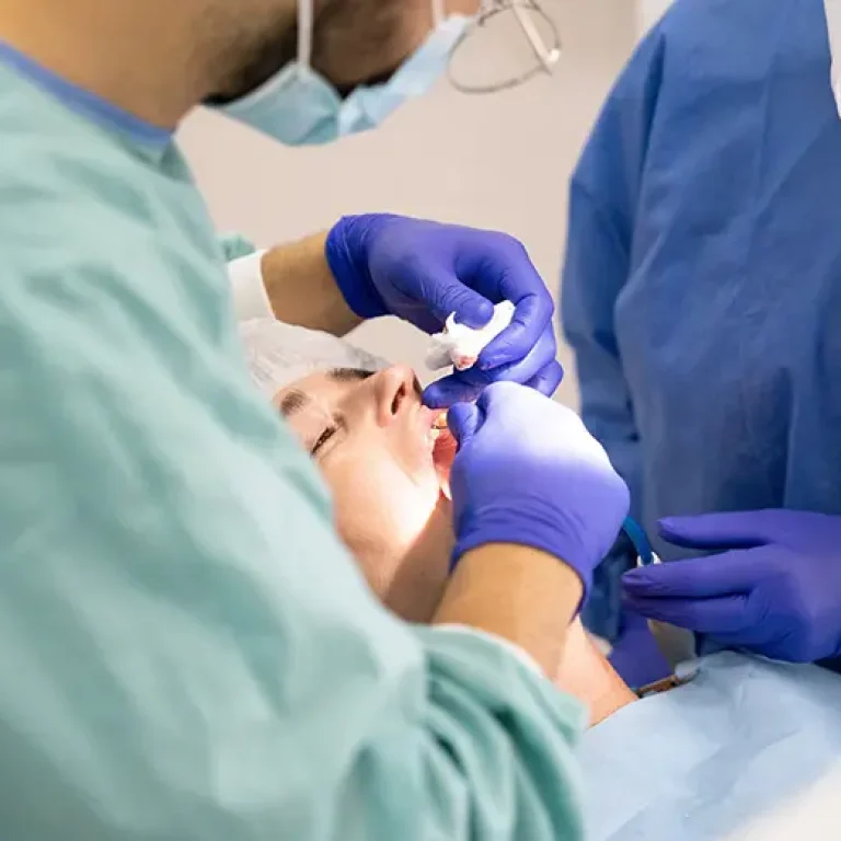 Dos profesionales de la Clínica Dental Vilà realizando un implante dental con precisión, en un entorno clínico especializado
